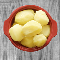Boiled potatoes in a pot, on wooden background
