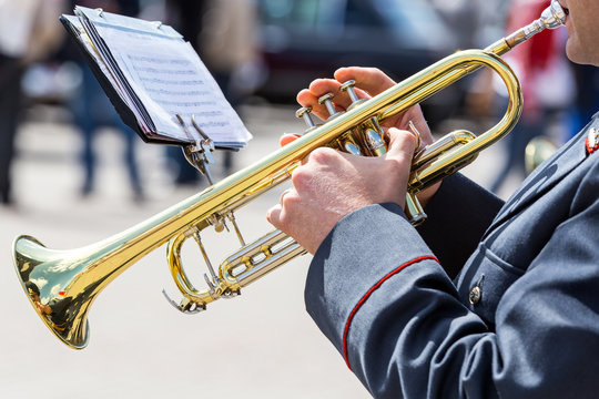 military musician playing on gold trumpet in army orchestra
