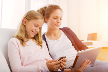 Attractive woman and little sister using tablet