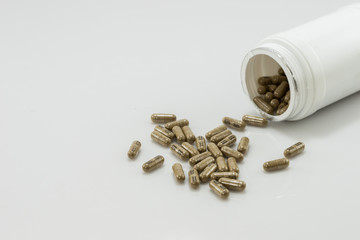herb capsules on white background