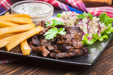 Kebab of beef with french fries and salad