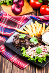 Kebab of beef with french fries and salad