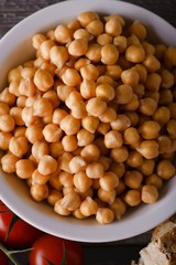 Bowl full of chickpeas on old wooden board