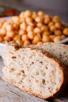 Detail of wholewheat bread in front of bowl with chickpeas