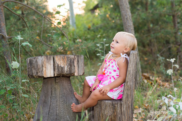 The child, a little girl playing in the woods, summer vacation, education and child development, forest interior, wooden furniture, in anticipation of a meal in a Fairy Tale