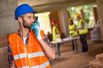 Man speaking on walky talky at site