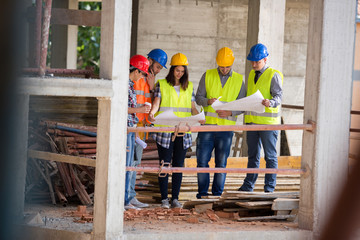 Team of experts studying blue print at construction site
