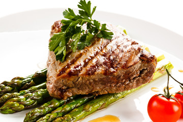 Grilled beefsteak and asparagus on white background 