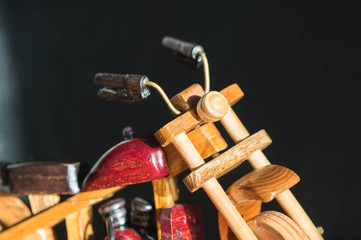 Wooden toy motorcycle on a dark background