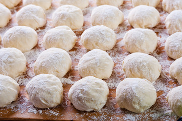 Fototapeta na wymiar Dough balls on a kitchen table