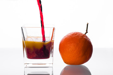 blackcurrant juice pouring into glass with orange juice