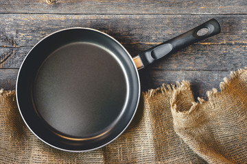 An empty pan on a wooden table - 103241599