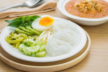 Rice noodles with boiled egg on plate and curry crab, Thai food