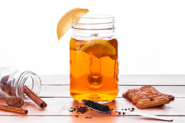 Hot spiced tea in jar on wooden table