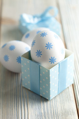 Easter egg in a gift box on wooden background