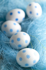 White Easter eggs in blue nest