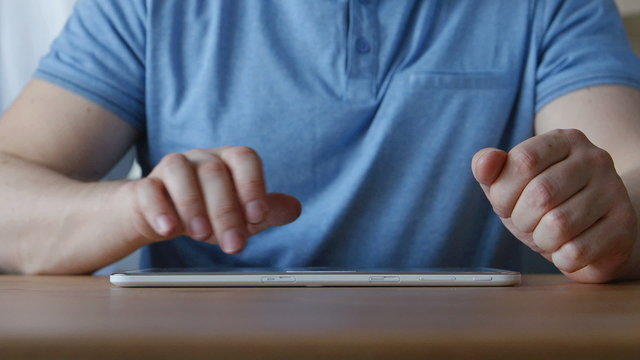 A hands of young man touching on a tablet PC at the table at home
