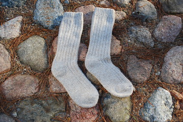Pair of wool socks on stones background.