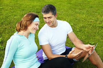 sports couple using digital tablet