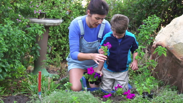 Mother and child planting flower seedlings in the garden, South Africa