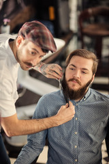 Obraz premium Hairdresser shaving with scissors and combs.
