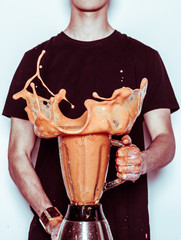 Man holding splashing blender