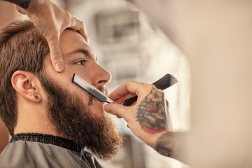 Barber with old-fashioned black razor.