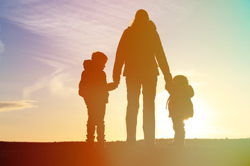 mother and two kids travel at sunset