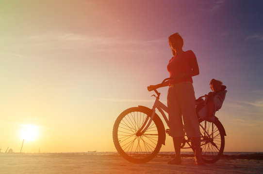 Silhouette of mother and baby biking at sunset © nadezhda1906