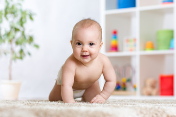 adorable baby crawling on carpet at home