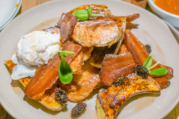 French toast with bacon, poached egg, grilled banana and berries