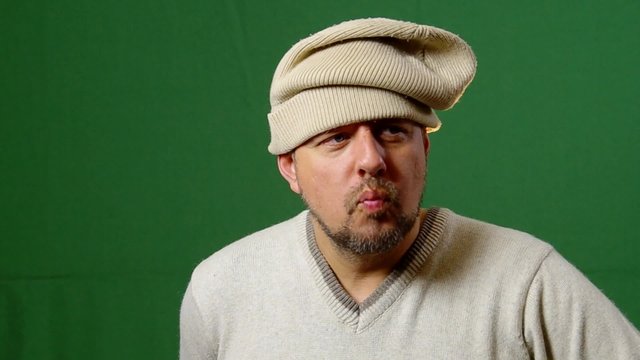 Actor improvise over a green background. 