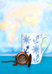 compass and a cup on the world map