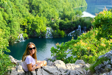 Plitvice Lakes with beustiful woman laying on the rocks