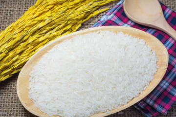 Rice in wooden bowl on Sack or wood table background