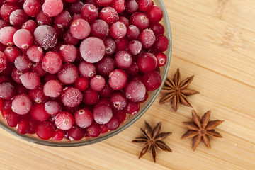 Ice cranberries with anice on wooden table.