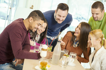 Friends smiling and sitting in a cafe