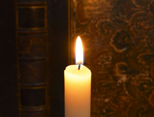 burning candle and antique book background