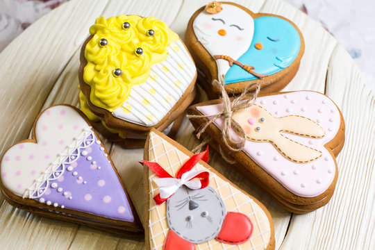 a collection of gingerbread cookies in the shape of a heart, muffins and animals on a white wooden background