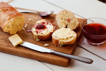 Toasts with jam on plate and cup of tea on bright background