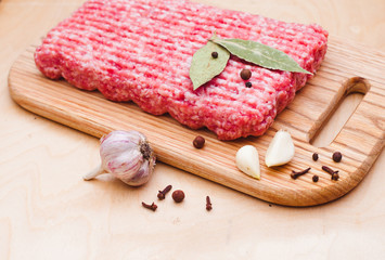 minced meat on a cutting board on a wooden background