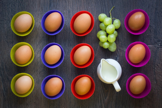Eggs in colourful cupcake cups with grapes and a milk jar