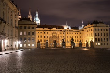 Obraz na płótnie Canvas Night Picture of the main entrance to the Prague castle in Prague in Czech Republic. Gate of giants, with baroque statues on the top of pilots. Buildings of the caste are residence of czech president.