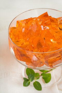 Orange G&ouml;tterspeise in einer Dessertschale steht auf einem Tisch