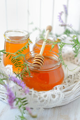 Three jars full of honey and wildflowers 