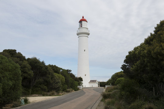 Camino hacia un faro alto y blanco en la Great Ocean road, Australia