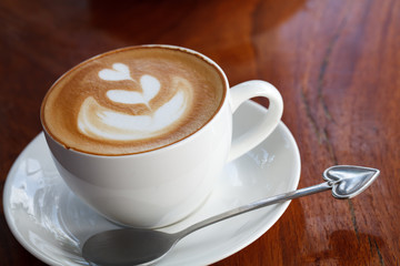 Close-up latte art coffee on wood background.