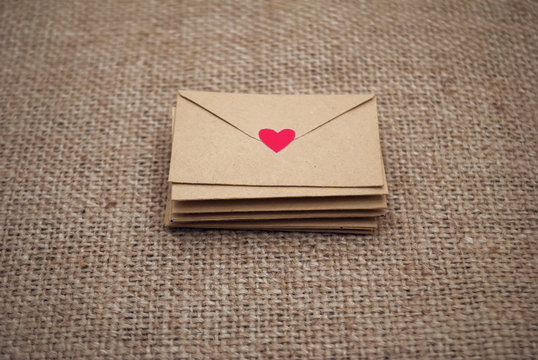 Romantic envelope with heart and love letter on fabric background. The best present for valentines day.