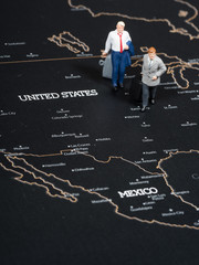 Miniature business man on map of US, Mexico