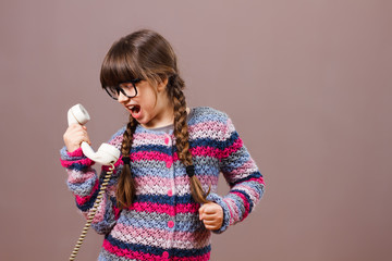 Little nerdy girl is shouting at the phone